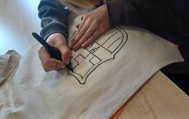 Dziecko szkicujęce na kawałku materiału