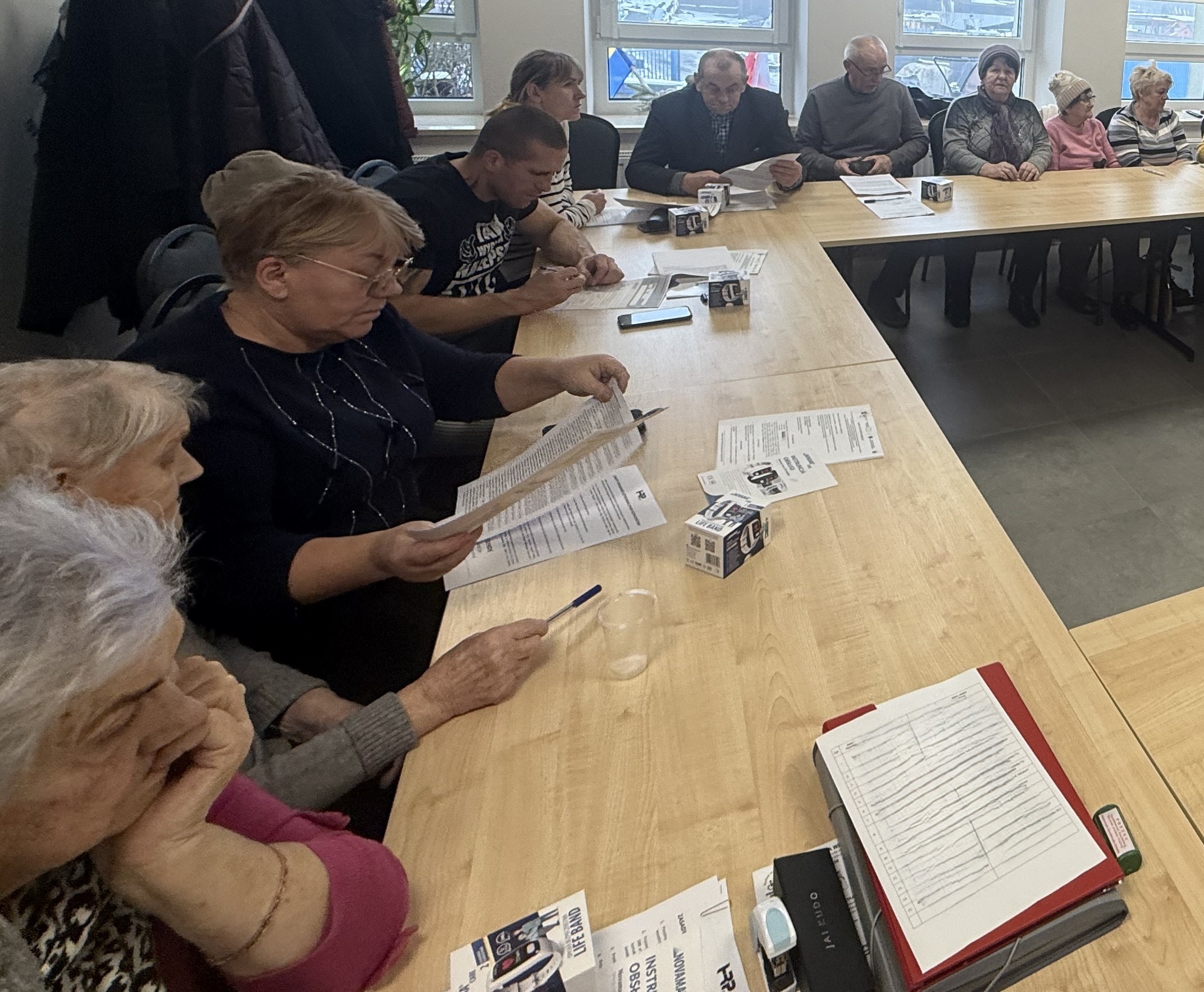 Osoby siedzą przy stole